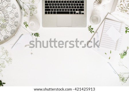 Workspace with laptop, headphones, pen, notebook, sketchbook, white vintage tray, candlesticks on white background. Flat lay, top view. Freelancer working place