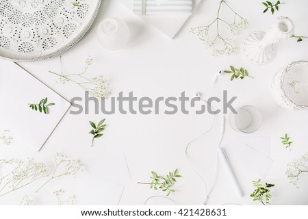 Workspace with headphones, pen, notebook, sketchbook, white vintage tray, candlesticks on white background. Flat lay, top view. Freelancer working place