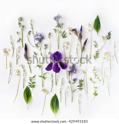 Pattern with purple iris and lily of the valley flowers on white background. Flat lay, top view