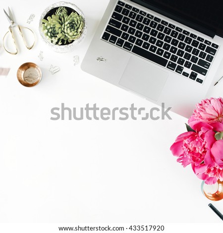 Workplace with laptop, succulent, peonies, golden scissors, spool with beige ribbon, pencils and diary. Flat lay composition for bloggers, magazines, social media and artists. Top view.