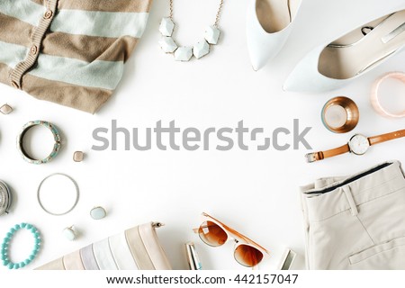 flat lay feminine clothes and accessories collage with cardigan, trousers, sunglasses, watch, bracelet, lipstick, mint high heel shoes, earrings and purse on white background.