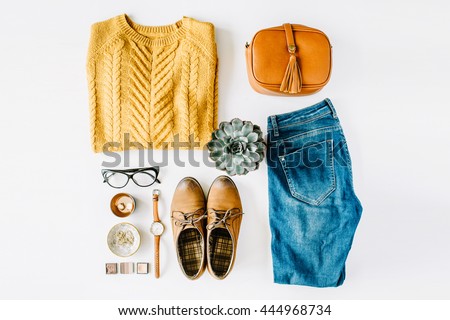 flat lay feminini clothes and accessories collage with brown cardigan, jeans, glasses, watch, earrings, purse, boots and succulent on white background.