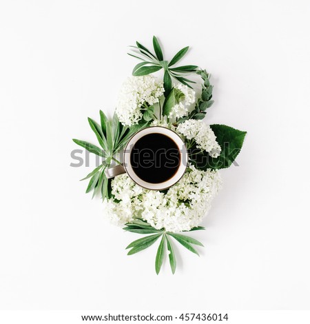 black coffee mug and white hydrangea flowers bouquet on white background. flat lay, top view