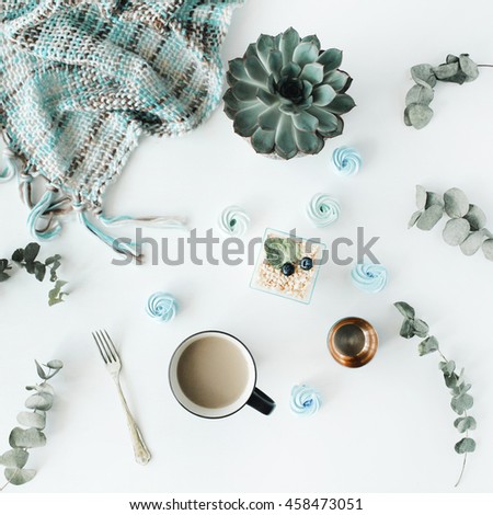 Breakfast composition with coffee with milk, blue cakes, succulent, fork, eucalyptus, plaid on with background. Flat lay, top view