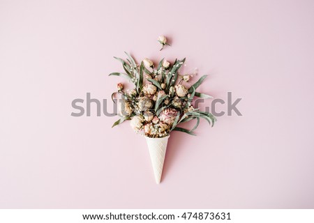 waffle cone with roses bouquet on pink background, flat lay, top view