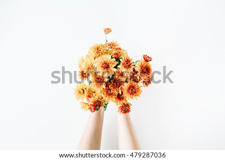 chrysanthemum bouquet in girl\'s hands on white background. flat lay, top view concept