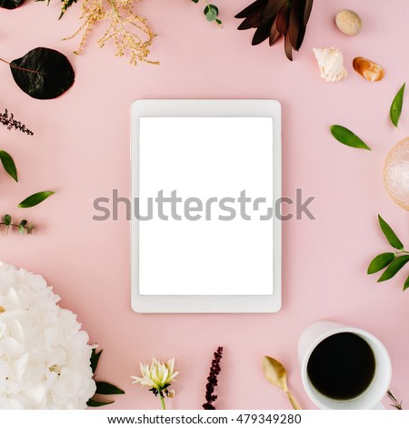 creative decorated and arranged flat lay frame concept with tablet, vintage tray, hydrangea, shells, coffee, golden spoon, branches on pink background. top view