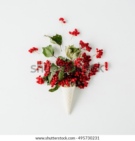 ice cream waffle cone with red rowan bouquet on white background, flat lay, top view. autumn wallpaper