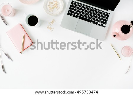 Flat lay fashion feminine home office workspace. Laptop, pink teapot, golden pen and clips. Top view