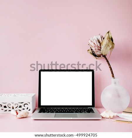 Laptop with blank screen on table with proteus flower and decoration