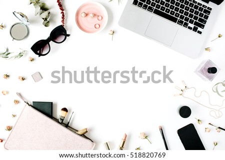 Flat lay, top view office table desk frame. feminine desk workspace with laptop, clutch, cosmetics, phone, sunglasses, lipstick rose buds on white background.