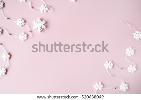 white christmas snowflakes decoration on pink background. christmas wallpaper. flat lay, top view