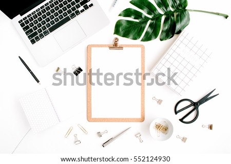 Home office workspace mockup with laptop, clipboard, palm leaf, notebook and accessories. Flat lay, top view
