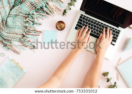 Flat lay home office desk. Female workspace with laptop, eucalyptus branch, accessories on pink background. Top view feminine background. Lifestyle blog hero.