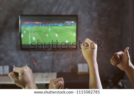 Happy time of friendship watching football game on TV and celebrating victory at home.Friendship, sports and entertainment concept.