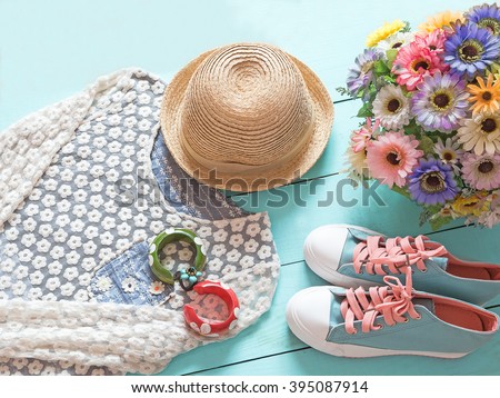 Pastel colors cozy clothing of spring and other stuff on blue wooden background