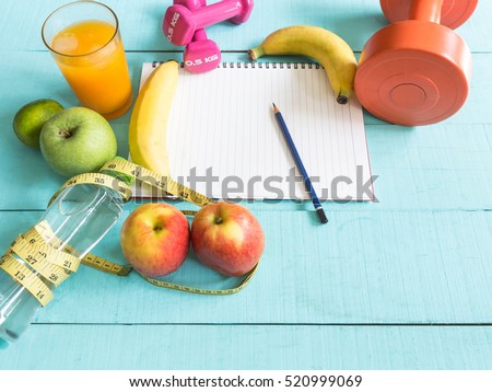 Healthy eating ,Workout and fitness dieting ,fitness and weight loss concept, tape measure, banana, apple, fruit and water bottle, blank copy space notebook,on wooden background
