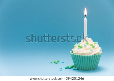 cupcake with burning candle and blue background