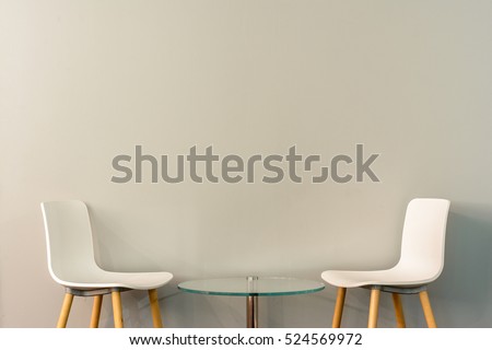 Chairs in modern design arranged in front of the gradient grey wall for interior or graphic backgrounds. The chairs can be used to represent interview sessions or waiting rooms for ads purpose.