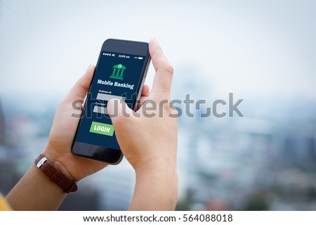 Female hands hold mobile banking on smart phone on blurred urban city as background