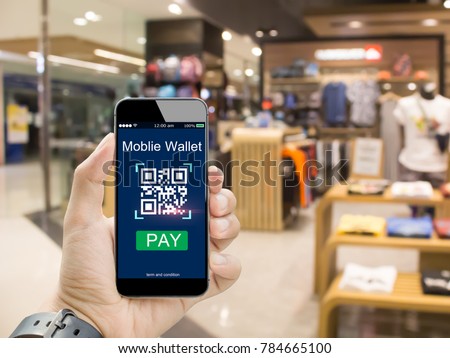 Moblie wallet payment with qr code concept.Hands holding mobile phone on  blurred clothing shop in department store\
as background