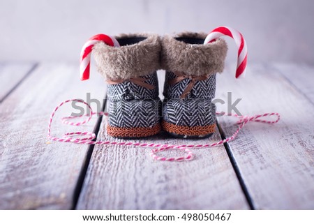 Christmas composition - new year holiday toy for christmas tree - shoes boots and cany cane on wooden background