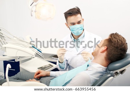A young male dentist and a patient