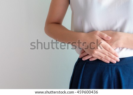woman stomach ache because of gastritis or menstruation that are sign of stomach trouble with grey background tone