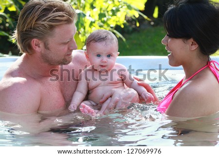 Couple and baby enjoy the hot tub