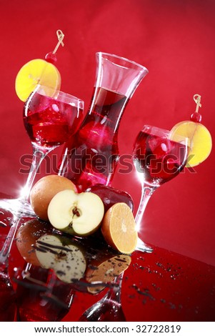 Carafe and sangria or fruit punch glasses wedged with an orange slice and maraschino cherry