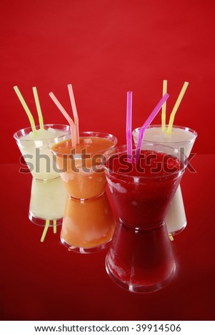 Lime, orange, vanilla and strawberry smoothies in plastic cups