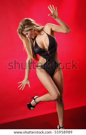 Expressions of a gorgeous blonde in stiletto shoes on red background