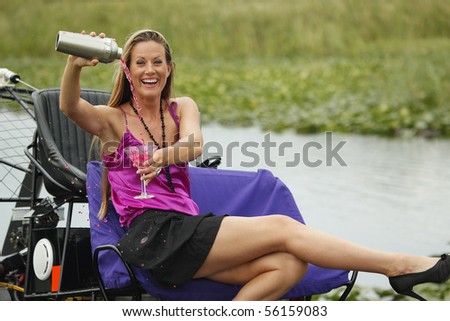 Pretty young lady enjoys a cocktail on an airboat