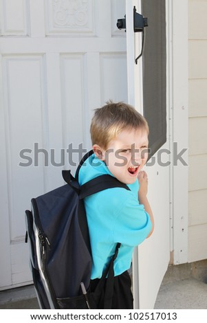 Boy with a backpack by the door, ready to go to school