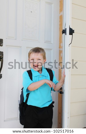 Boy with a backpack by the door, ready to go to school