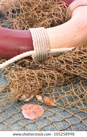 Life preserver with fishing nets and sea shells.  Beach or ocean concept.