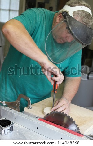 Man working with table saw, screwdriver and other tools