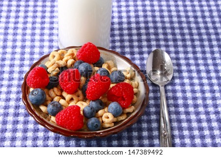 Breakfast cereal with berries on a blue tablecloth