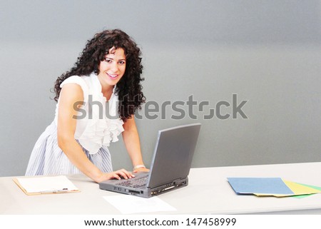 Happy young woman works on her laptop