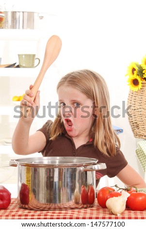 Little girl cooks soup with attitude