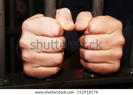 Man behind jail bars reaching out