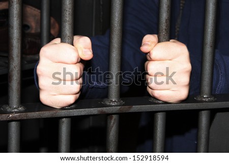 Man behind jail bars reaching out