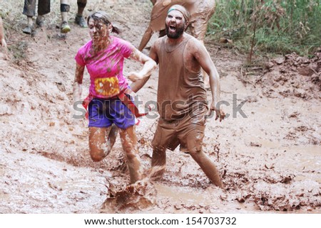 MUSKOGEE, OK - SEPT. 14 : Actors portraying zombies wait for runners to cross their mud pit  during the Castle Zombie Run at the Castle of Muskogee in Muskogee, OK on September 14 , 2013.