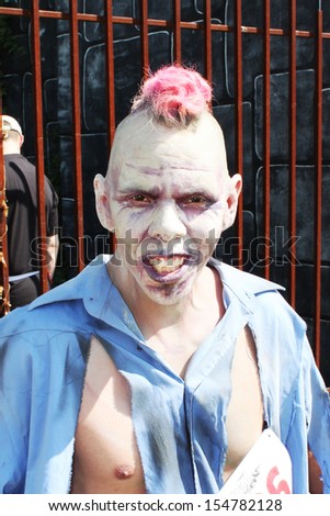 MUSKOGEE, OK - Sept. 14: A leader zombie catches some scares before the start of the first heat run during the Castle Zombie Run at the Castle of Muskogee in Muskogee, OK on September 14,  2013.