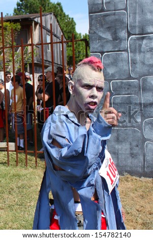 MUSKOGEE, OK - Sept. 14: A leader zombie catches some scares before the start of the first heat run during the Castle Zombie Run at the Castle of Muskogee in Muskogee, OK on September 14,  2013.