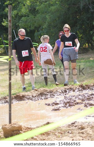 MUSKOGEE, OK - Sept. 14: Athletes run through mud and avoid zombies during the Castle Zombie Run at the Castle of Muskogee in Muskogee, OK on September 14, 2013.