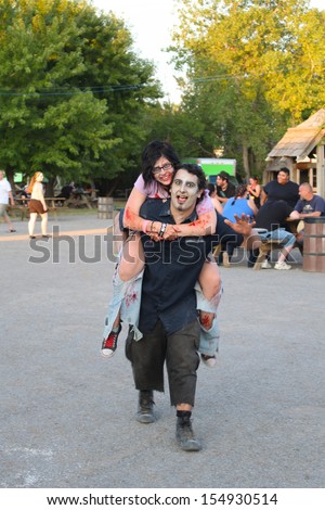 MUSKOGEE, OK - Sept. 14: Bloody zombies enjoy a piggy back ride after the Castle Zombie Run at the Castle of Muskogee in Muskogee, OK on September 14, 2013.