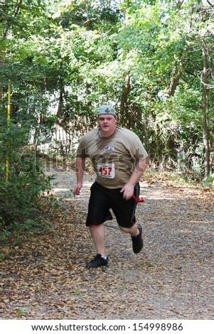 MUSKOGEE, OK - Sept. 14: Runners hurry through zombie-infested forest during the Castle Zombie Run at the Castle of Muskogee in Muskogee, OK on September 14, 2013.