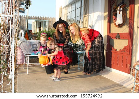 Little girls and their mothers check out candy after trick-or-treating