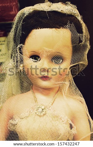 Old doll in ripped wedding outfit